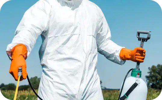 Licensed pest control technician in protective suit performing eco-safe treatment for Busy B Cleaning