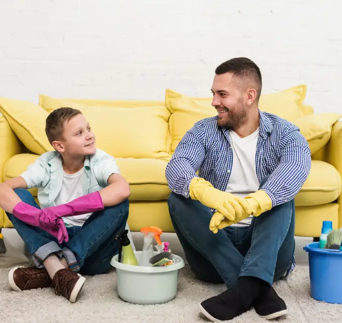 Father and son bonding over house cleaning with gloves and supplies — promoting family-friendly cleaning tips by Busy B Cleaning Australia