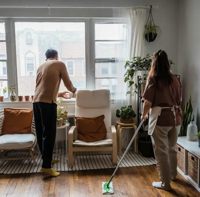 Couple tidying up living room during end-of-lease bond cleaning with support from Busy B Cleaning